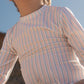 Close-up of fabric with orange and blue striped pattern of full coverage baby boy UV swimsuit.